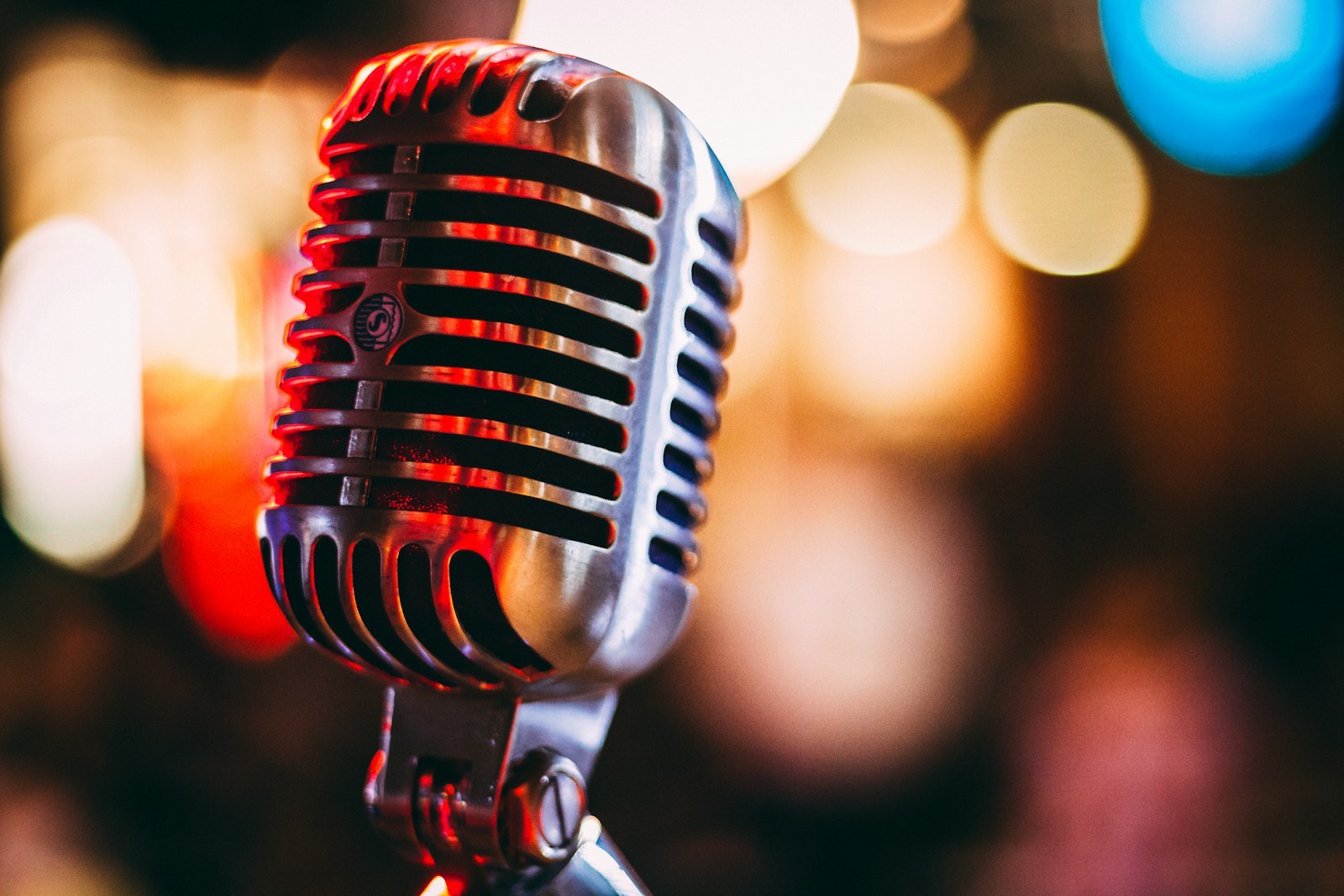 Vintage microphone with colored lights in the background.