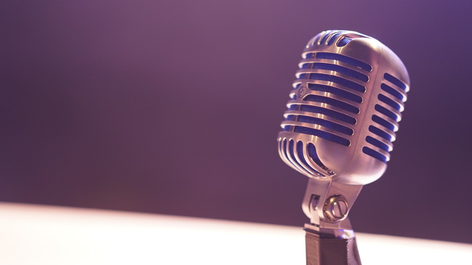 Microphone against a softly blurred dark background.