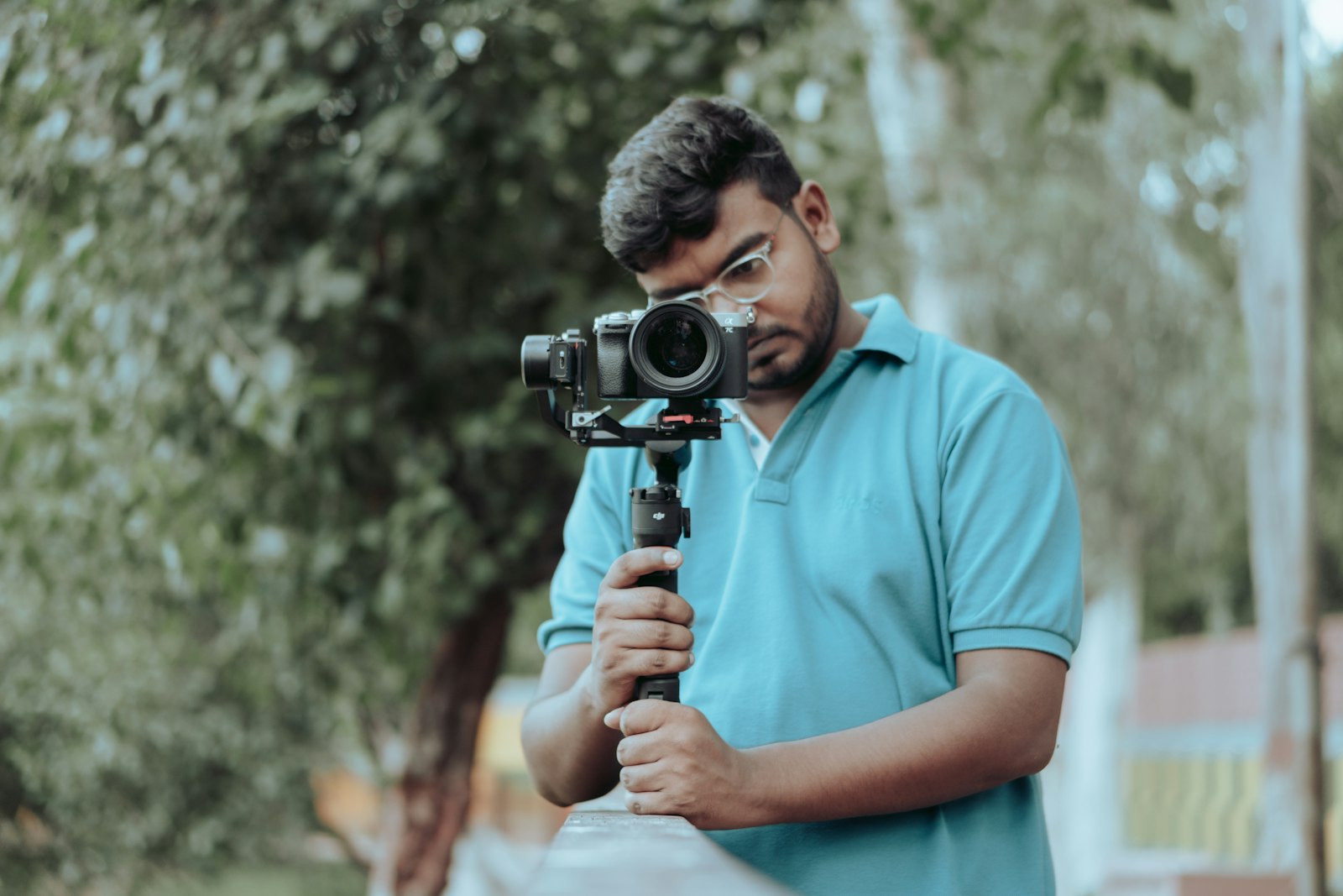 Man holding a camera mounted on a gimbal stabilizer.