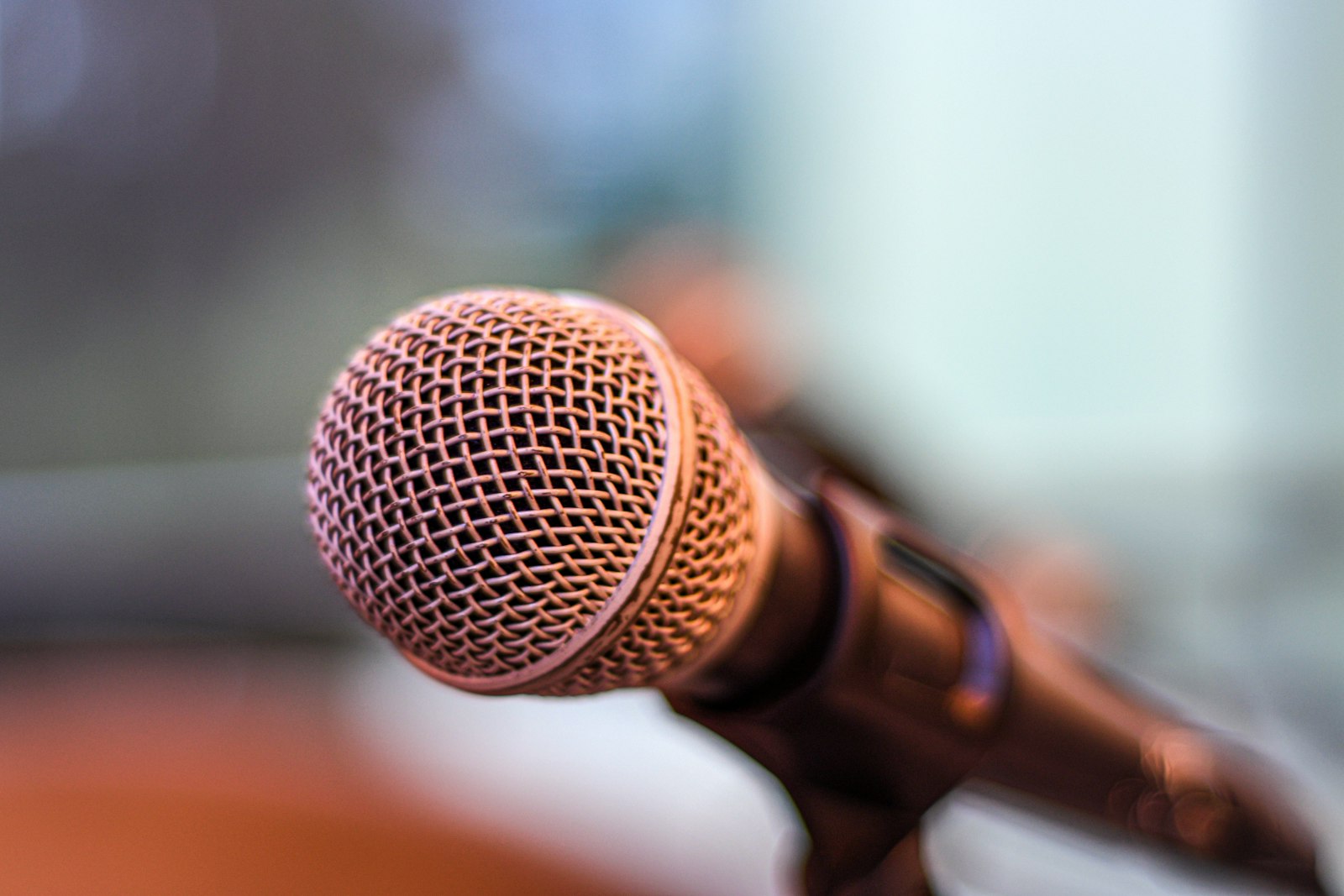 A vintage silver microphone against a blurred purple background.