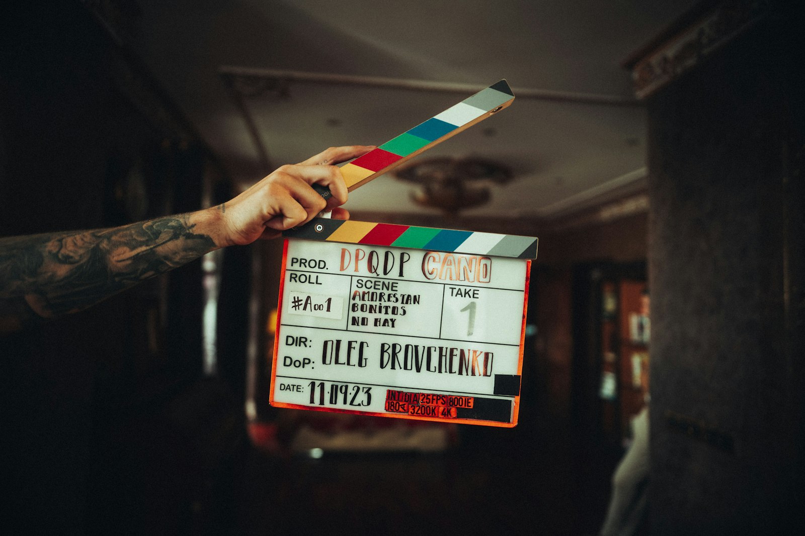 A person holding a film clapperboard in their hand.